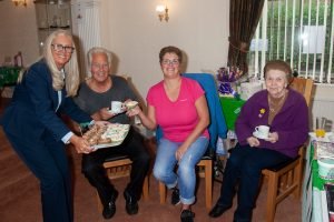 Funeral director serves coffee and cake to parents and daughter